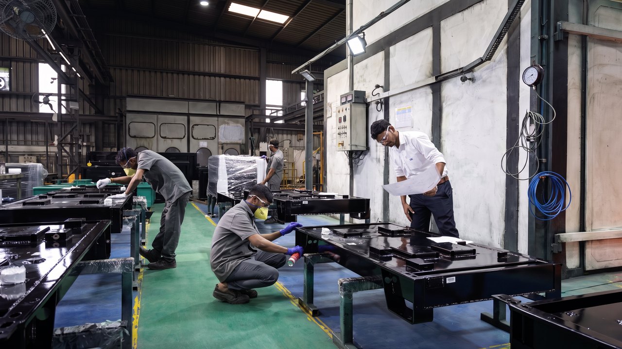 Fabricated assemblies staged along the plant floor with fitters working on them