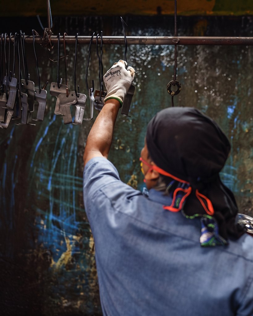 An operator hanging finished components on the powder-coating line