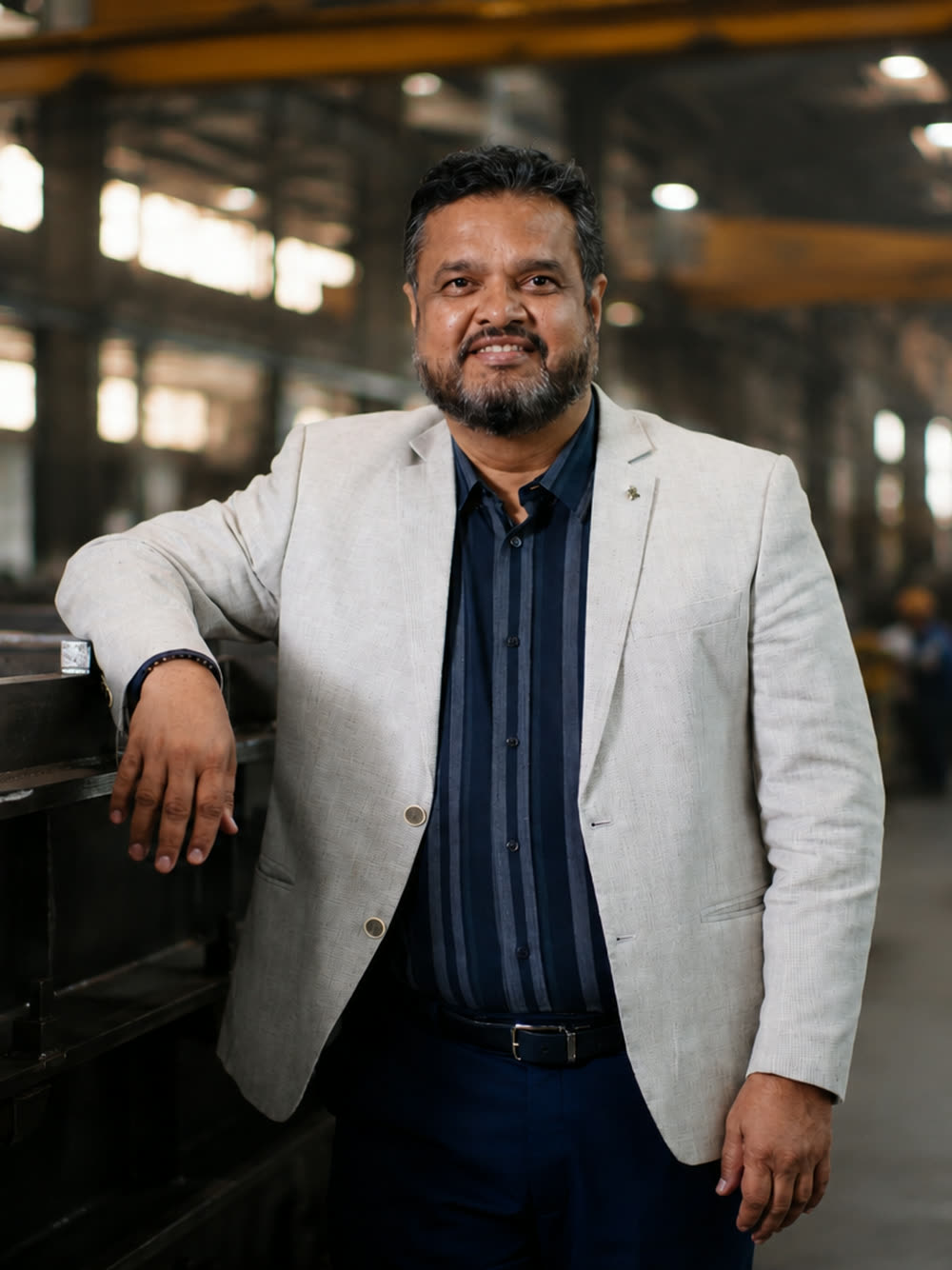 Abhay Ranade, Director of Operations and Quality, beside a welded base frame on the plant floor